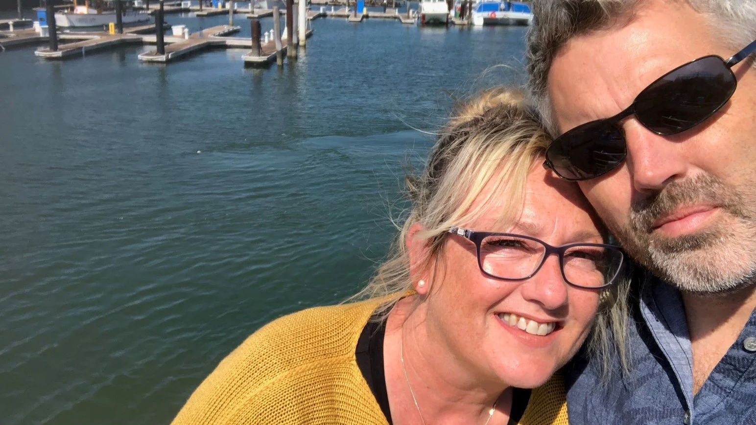 um homem e uma mulher tirando uma selfie à beira da água