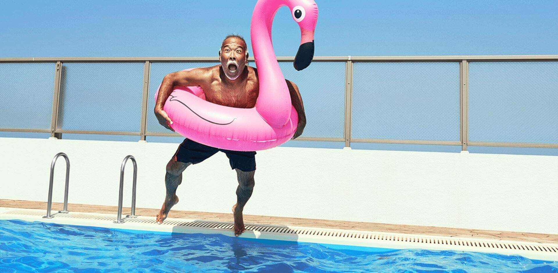 Homme joyeux sautant dans une piscine libéré de tout stress lié à sa stomie.